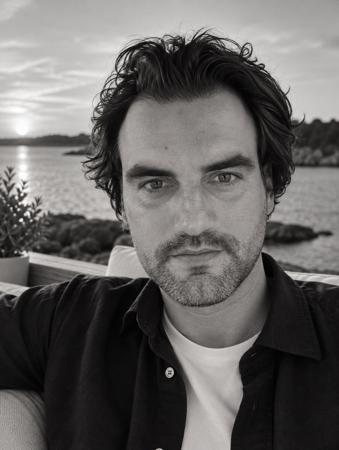 Black-and-white portrait of Pontus Olsson, founder of PSON1, outdoors by the water at dusk